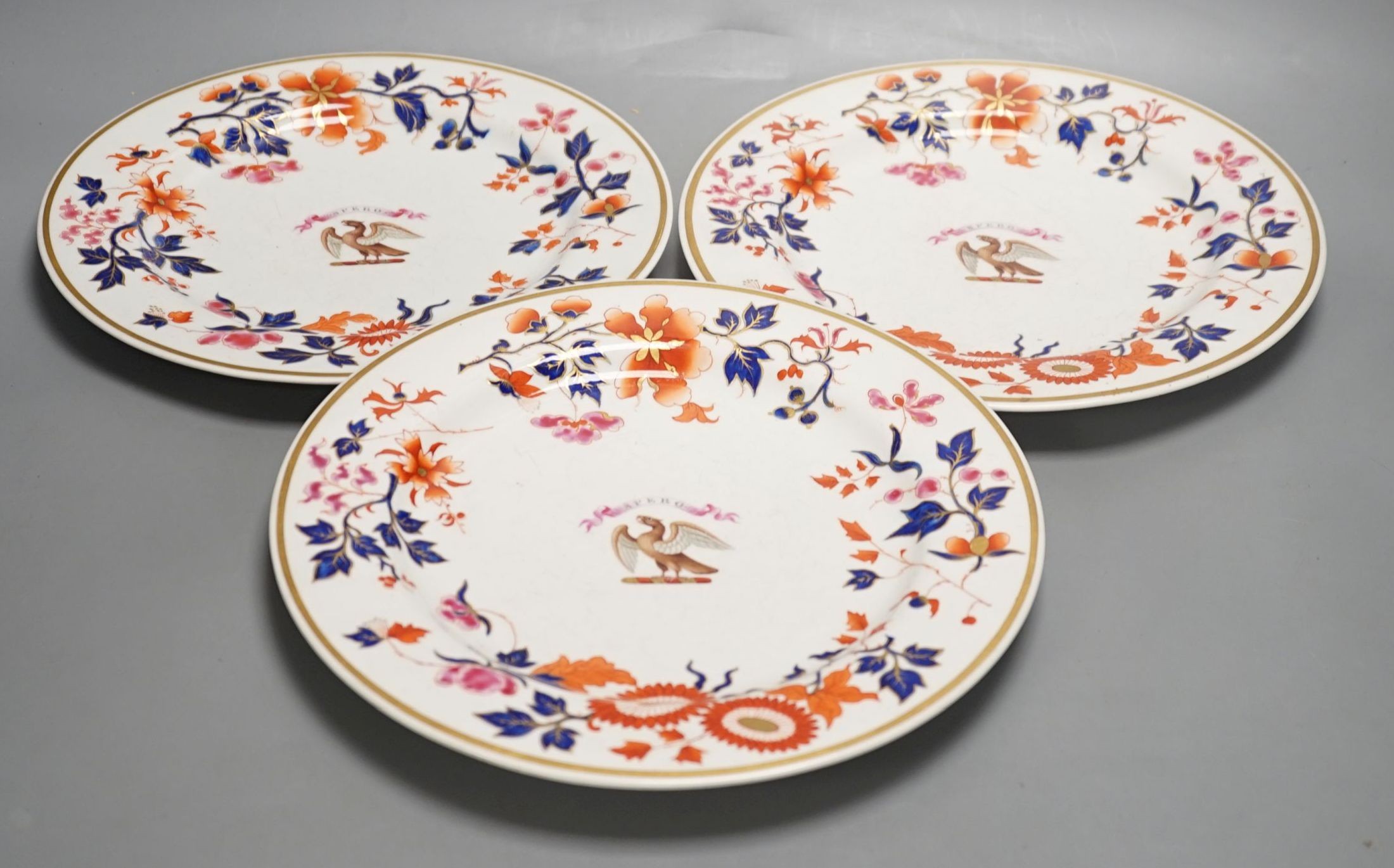 A Flight Barr and Barr set of three armorial plates decorated in imari style with leaves and flowers inscribed on a banner 'SPERO' (hope) above a hawk, c.1820, 26 cms diameter.